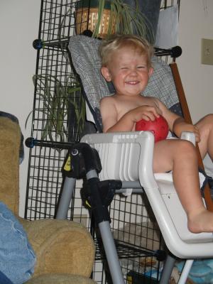 Noah sits in a high chair.