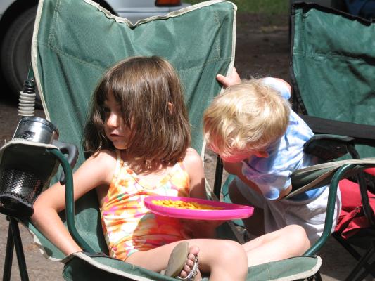 Andrea and Noah sit in a camp chair.
