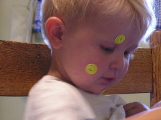 Noah plays with happy face stickers at great grandma's house.