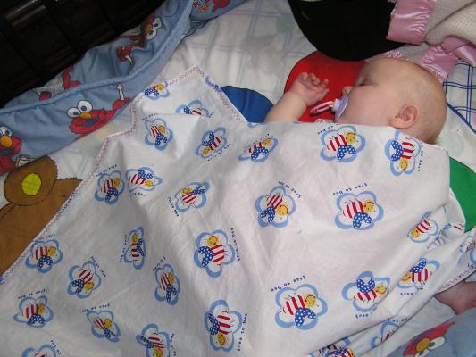 Sarah takes a nap with her 4th of July blanket.