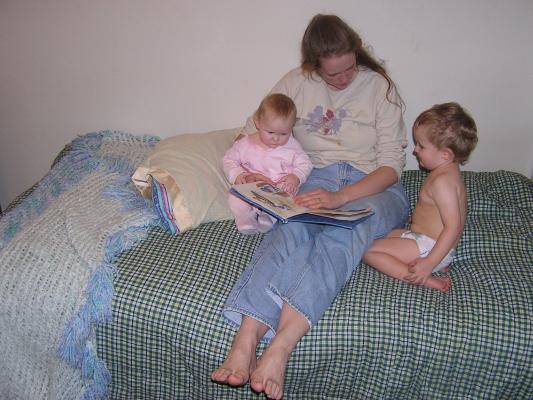 Katie reads to Sarah and Noah on the new bed.