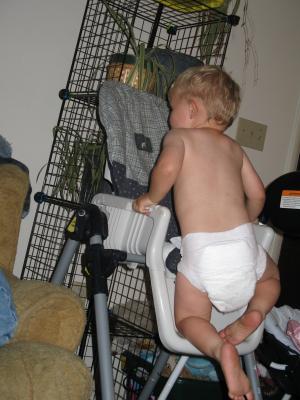 Noah climbs the high chair.